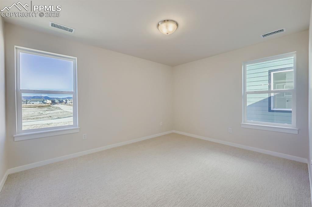 Image 17 of 27: Empty room with light colored carpet and baseboards