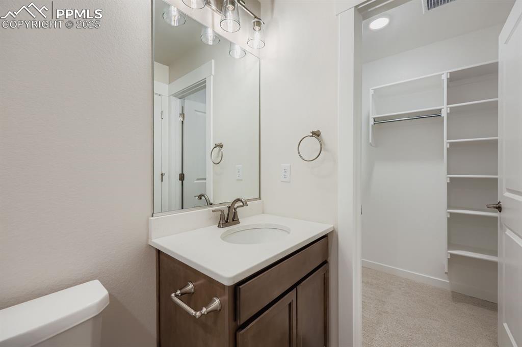Image 20 of 27: Half bath featuring vanity and light colored carpet