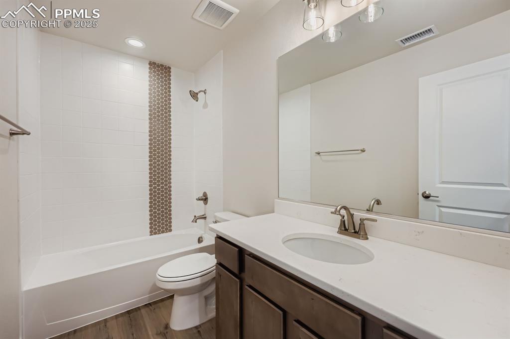 Image 21 of 27: Full bathroom with bathtub / shower combination, vanity, dark wood finished
