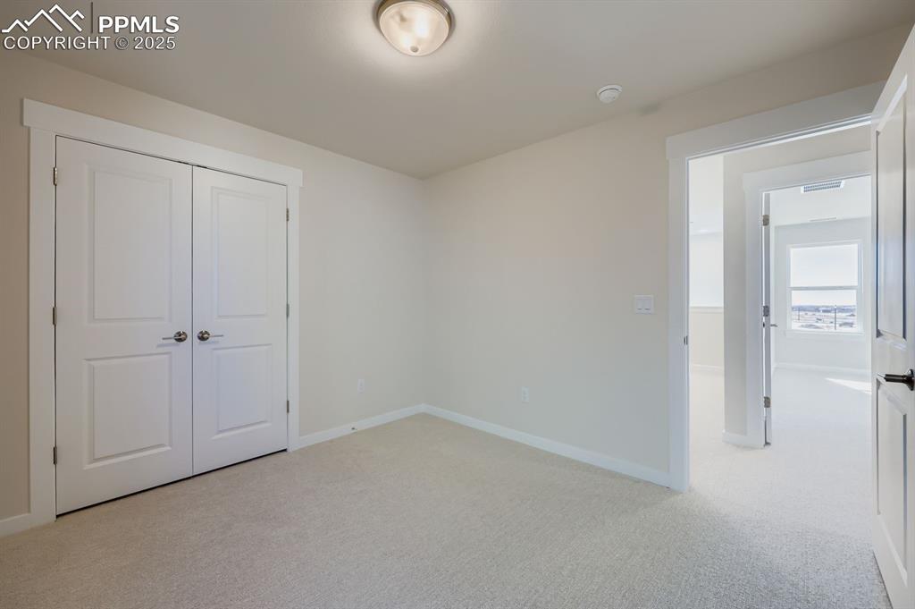 Image 22 of 27: Unfurnished bedroom featuring light carpet and a closet