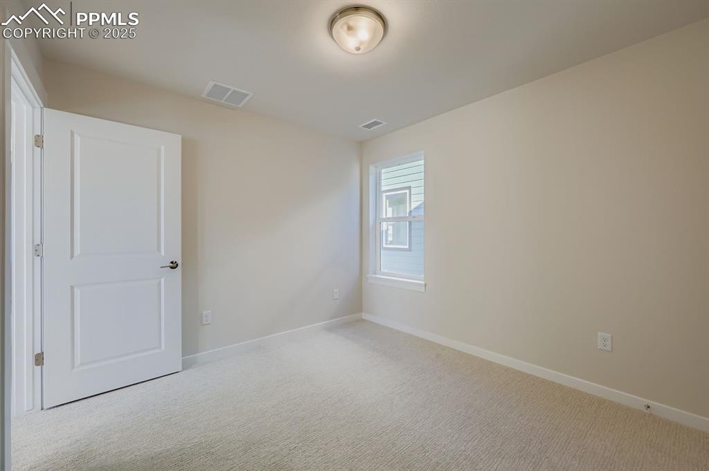 Image 23 of 27: Carpeted spare room with baseboards