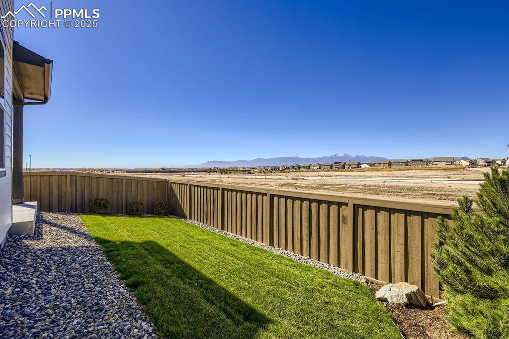 Image 26 of 27: Fenced backyard with a mountain view