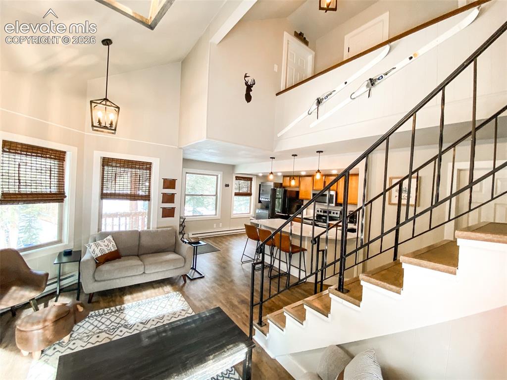 Image 11 of 29: Two-story living area featuring a vaulted ceiling and an open-concept desig