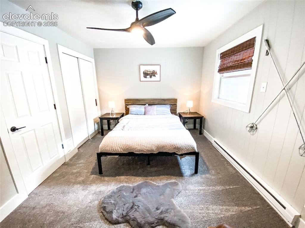 Image 15 of 29: Bedroom featuring a wood-panel accent wall, carpeted flooring, and a ceilin