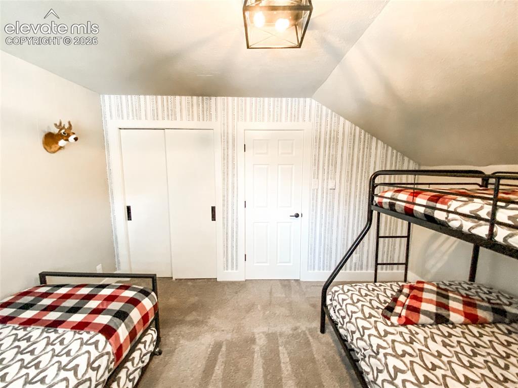 Image 19 of 29: Carpeted room featuring a sloped ceiling, light-colored walls, and a patter