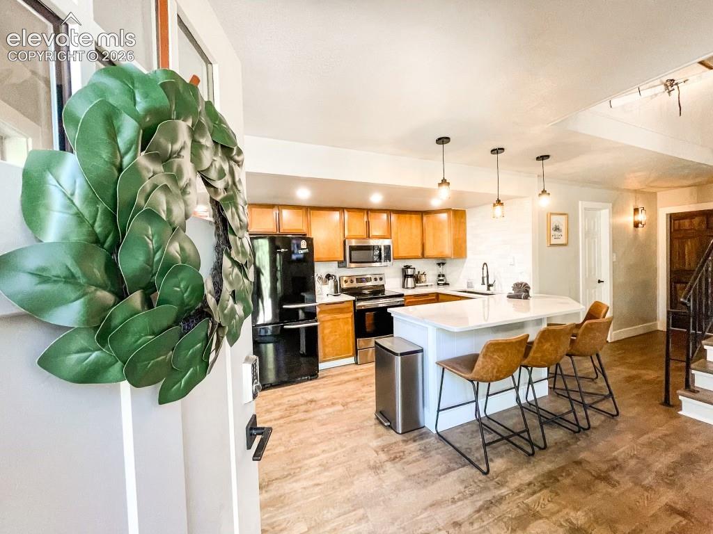 Image 2 of 29: Open-concept kitchen featuring wood-finish flooring, light wood cabinetry, 