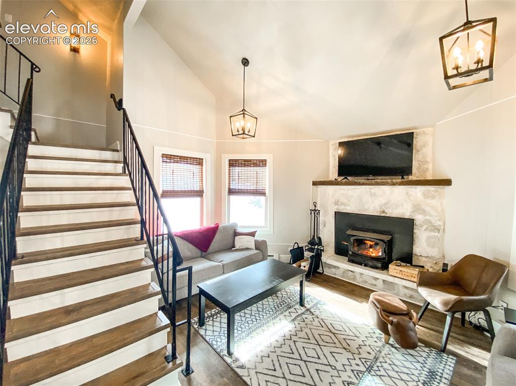 Image 20 of 29: Living room featuring a stone fireplace with a wood-burning stove insert, w