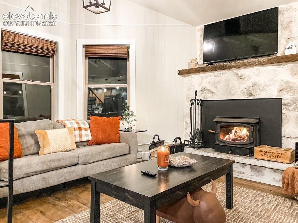 Image 25 of 29: Stone-faced fireplace with wood-burning stove insert