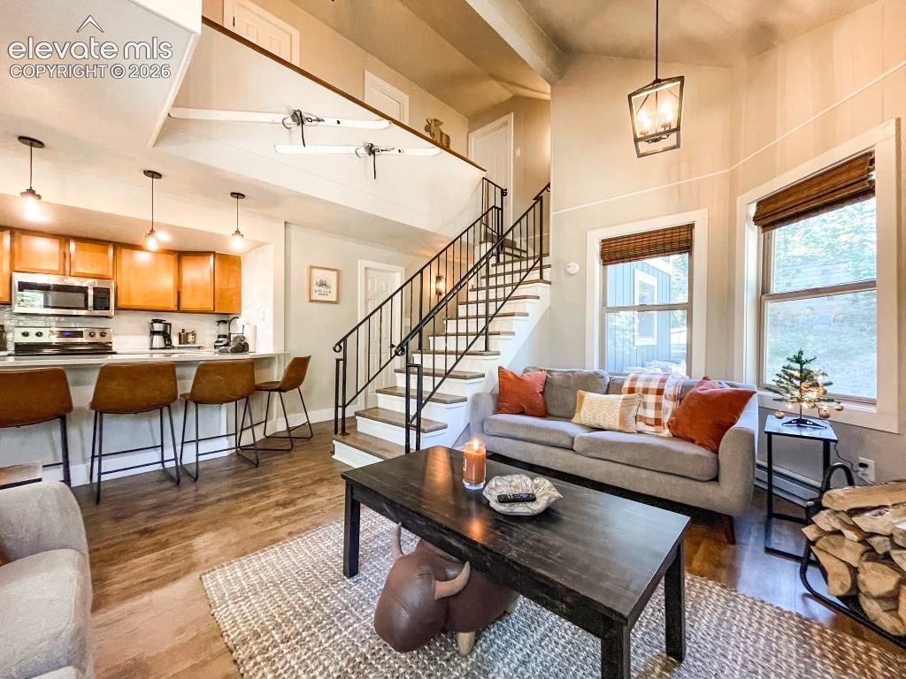Image 3 of 29: Open-concept living space featuring wood-finish flooring, a kitchen island 