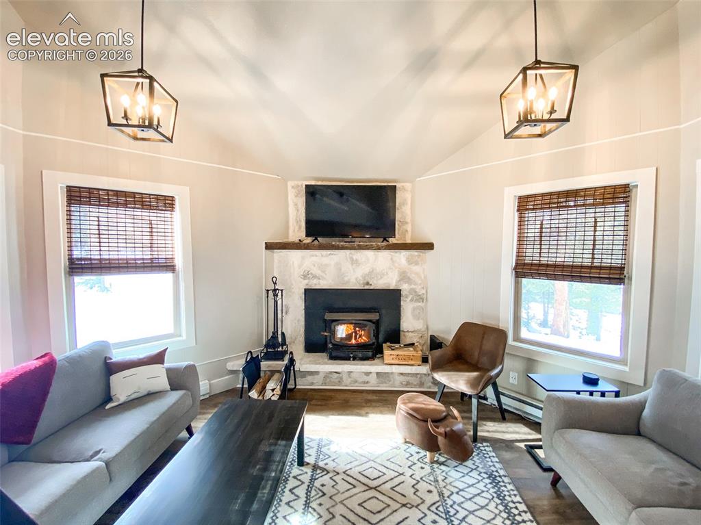 Image 5 of 29: Vaulted ceiling with exposed beam detailing and two geometric pendant light