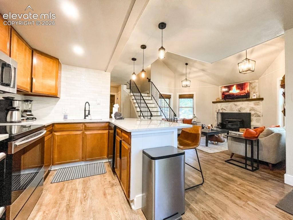 Image 7 of 29: Open-concept kitchen and living area featuring wood-finish flooring, a kitc