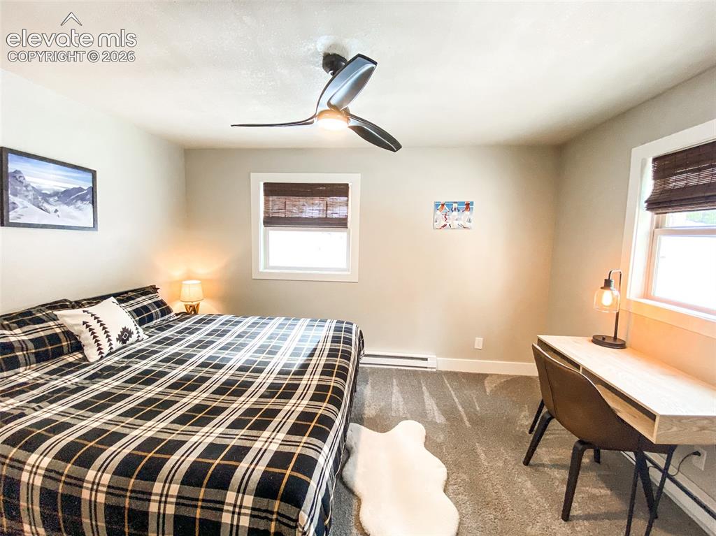 Image 9 of 29: Carpeted room featuring a ceiling fan with integrated lighting, two windows