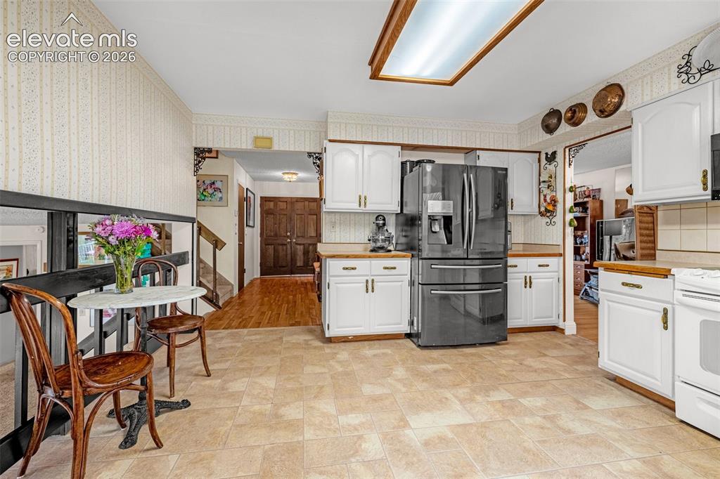 Image 13 of 45: Kitchen featuring white cabinetry, light countertops, and tile flooring