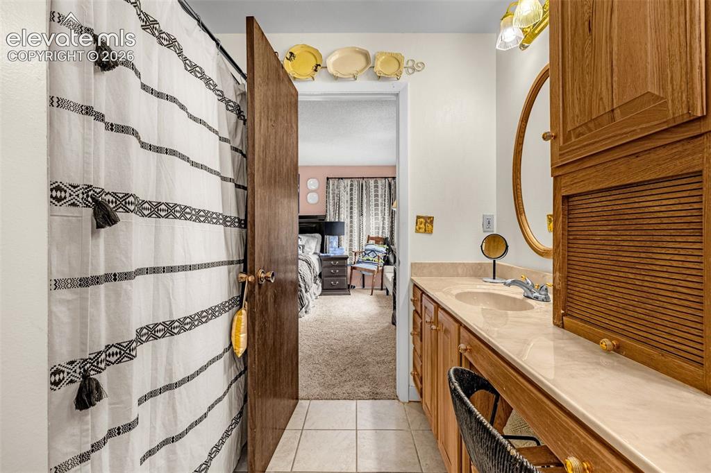 Image 19 of 45: Vanity with an integrated sink, a light-toned countertop, wood-finish cabin