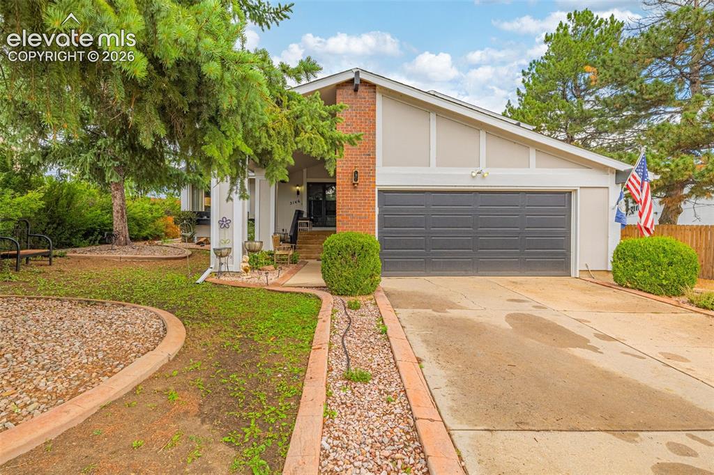 Image 2 of 45: Front exterior featuring brick and siding facade, a two-car garage, and mat