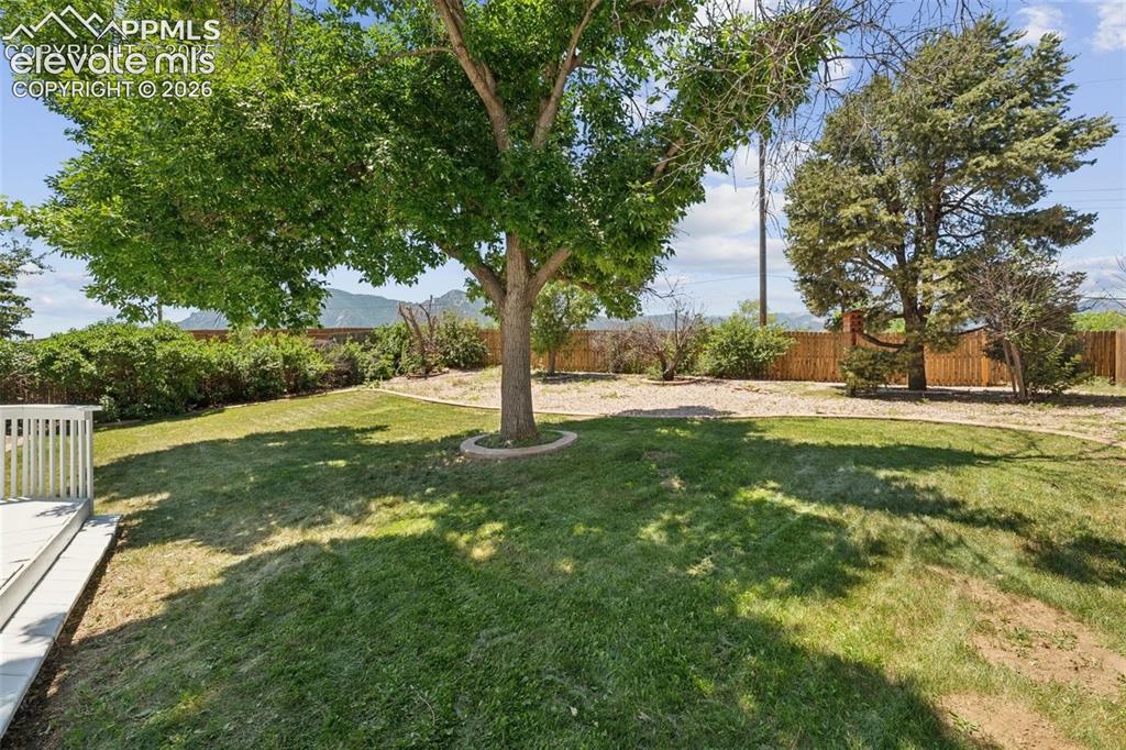 Image 35 of 42: Expansive outdoor space featuring a manicured lawn, established trees, and