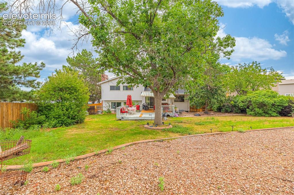 Image 38 of 45: Expansive backyard with a wood privacy fence, mature trees, and a spacious 