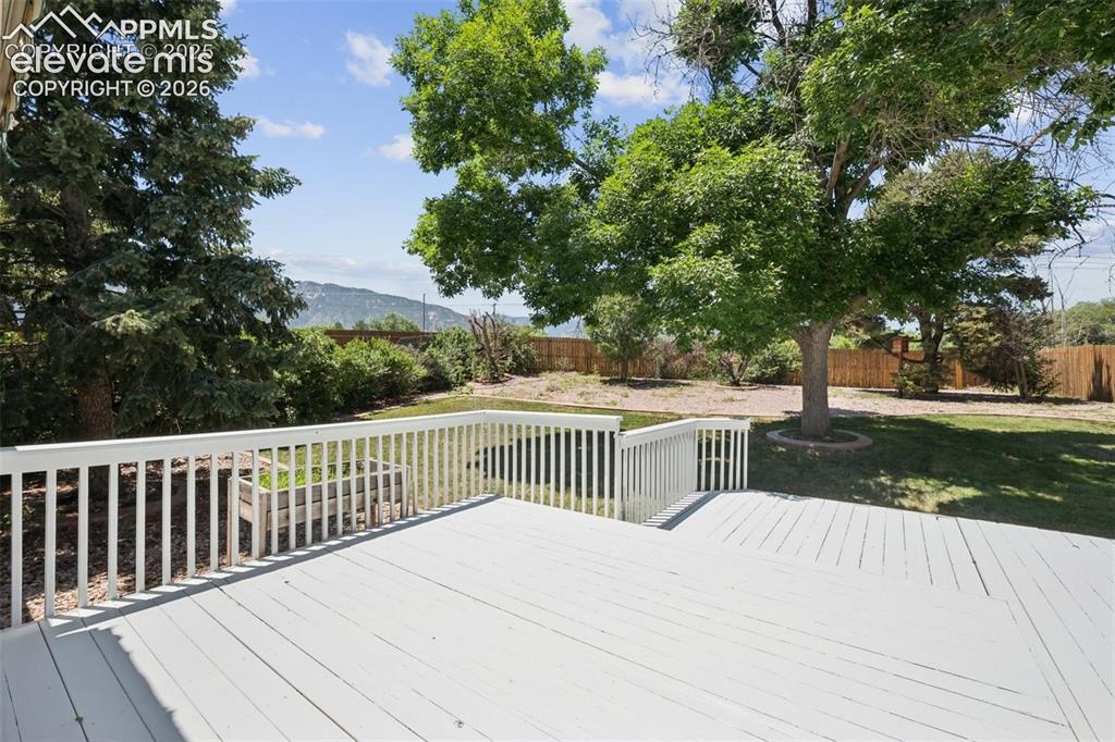 Image 42 of 42: Expansive outdoor deck with white railing, overlooking a generous lawn area