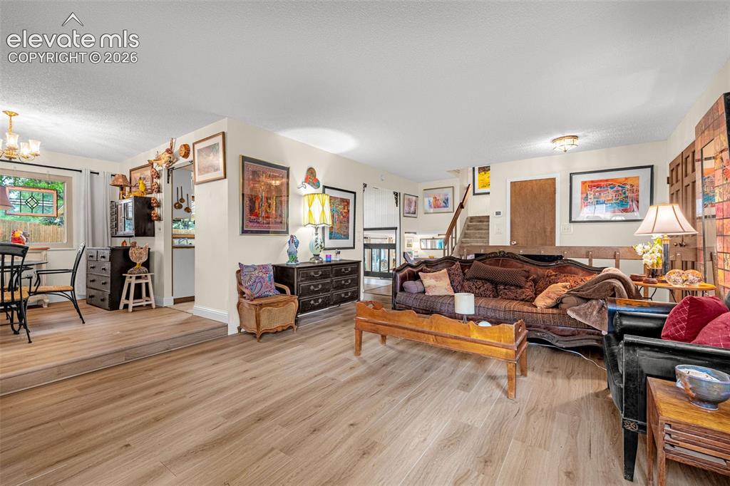 Image 6 of 45: Open-concept living area featuring wood-finish flooring, recessed lighting,