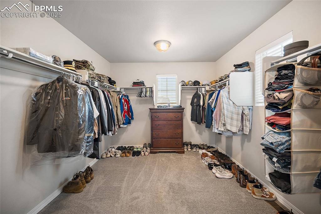 Image 25 of 40: Primary closet with lots of natural lighting. Located above front entrance.