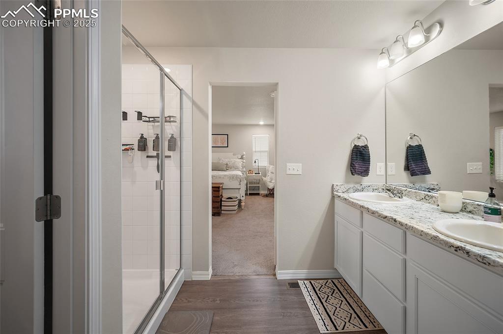 Image 26 of 40: Primary bathroom with direct access to the bedroom, featuring a double vani