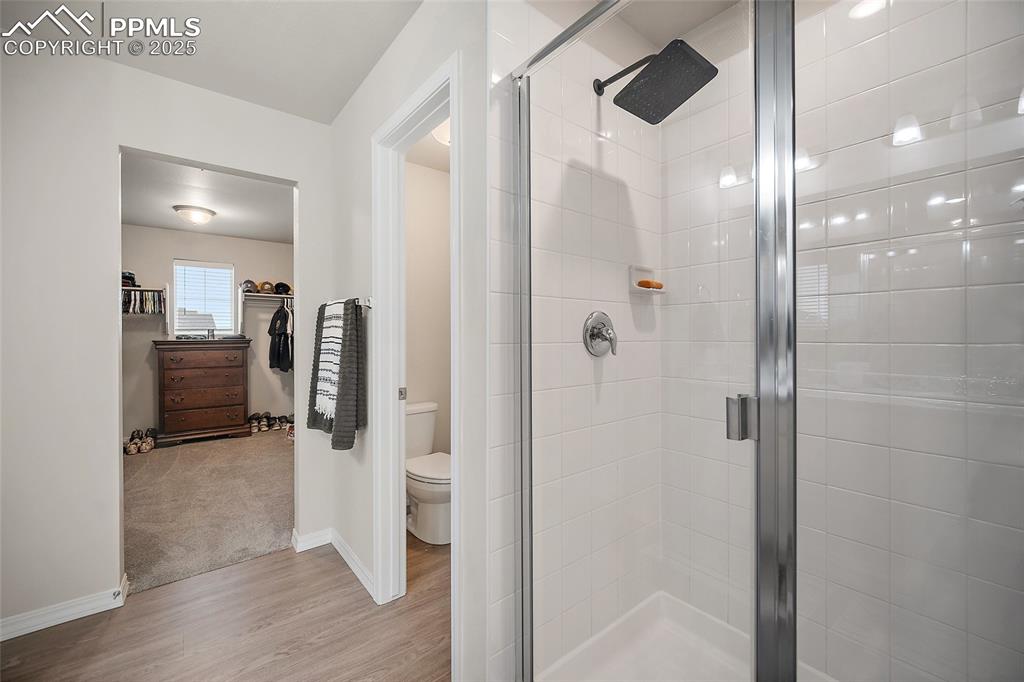 Image 27 of 40: Primary shower, private toilet room and closet.