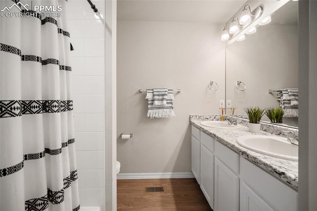 Image 28 of 40: Upstairs hall bathroom featuring double vanity, adjacent to loft and bedroo