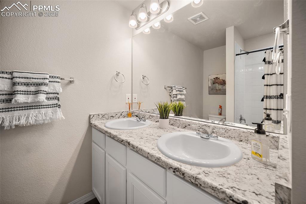 Image 29 of 40: Upstairs hall bathroom featuring double vanity, adjacent to loft and bedroo