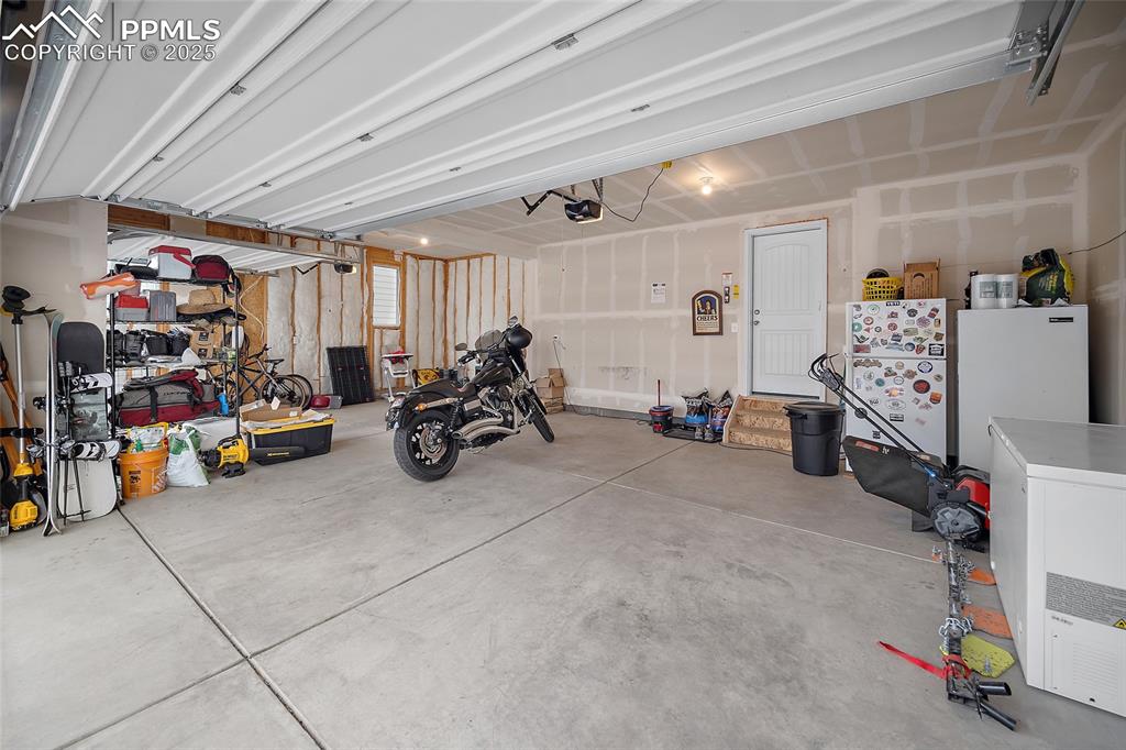 Image 34 of 40: 3 car garage with access door leading to the kitchen area