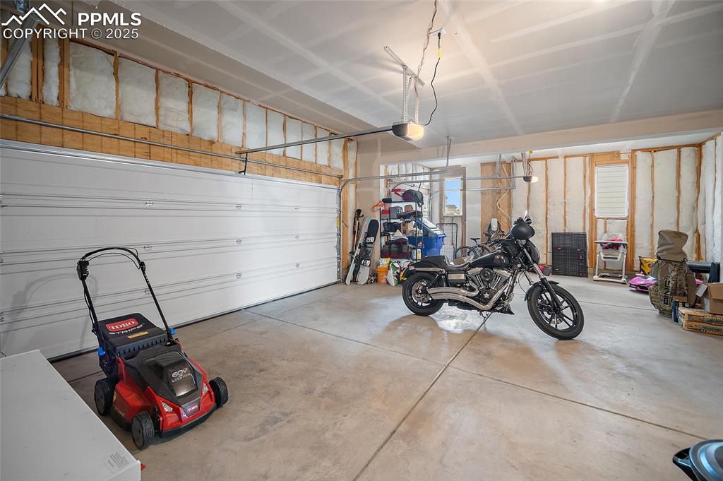 Image 35 of 40: 3 car insulated garage with two windows that feature natural light.