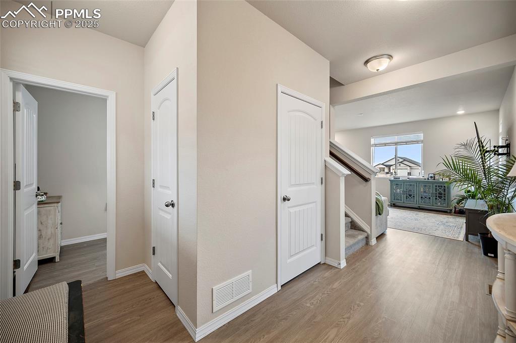 Image 6 of 40: Front entrance with access to a half bath, coat closet, downstairs and livi