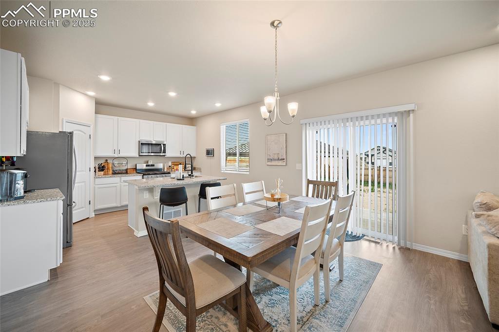 Image 9 of 40: Dining space featuring light wood-style flooring, a chandelier, and recesse