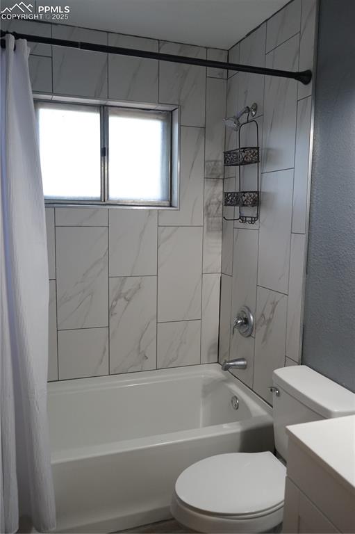 Image 11 of 22: Bathroom with shower / bath combo with shower curtain, a textured wall, and