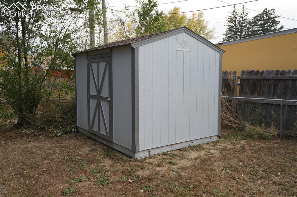 Image 18 of 22: View of shed with a fenced backyard