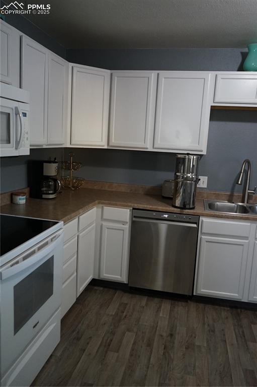 Image 5 of 22: Kitchen with stove, white cabinetry, dishwasher, and dark wood-type floorin