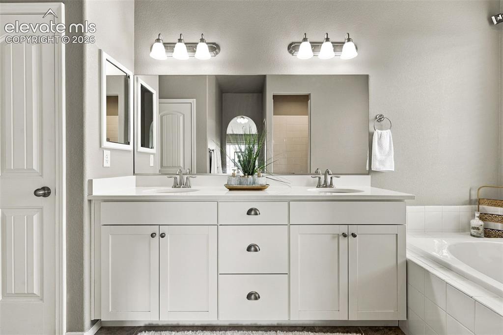 Image 28 of 49: Primary bath with dual vanities and generous storage.