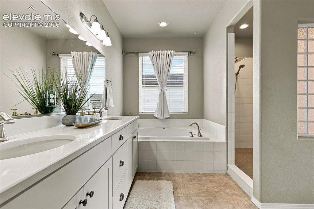 Image 29 of 49: Bright primary bath with large vanity and natural light.