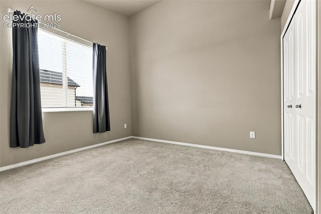 Image 31 of 49: Secondary main-level bedroom with natural light.