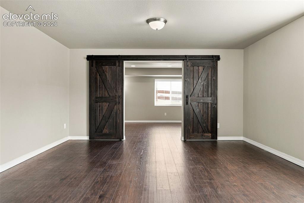 Image 37 of 49: Barn doors create a distinctive entrance to the theater room.