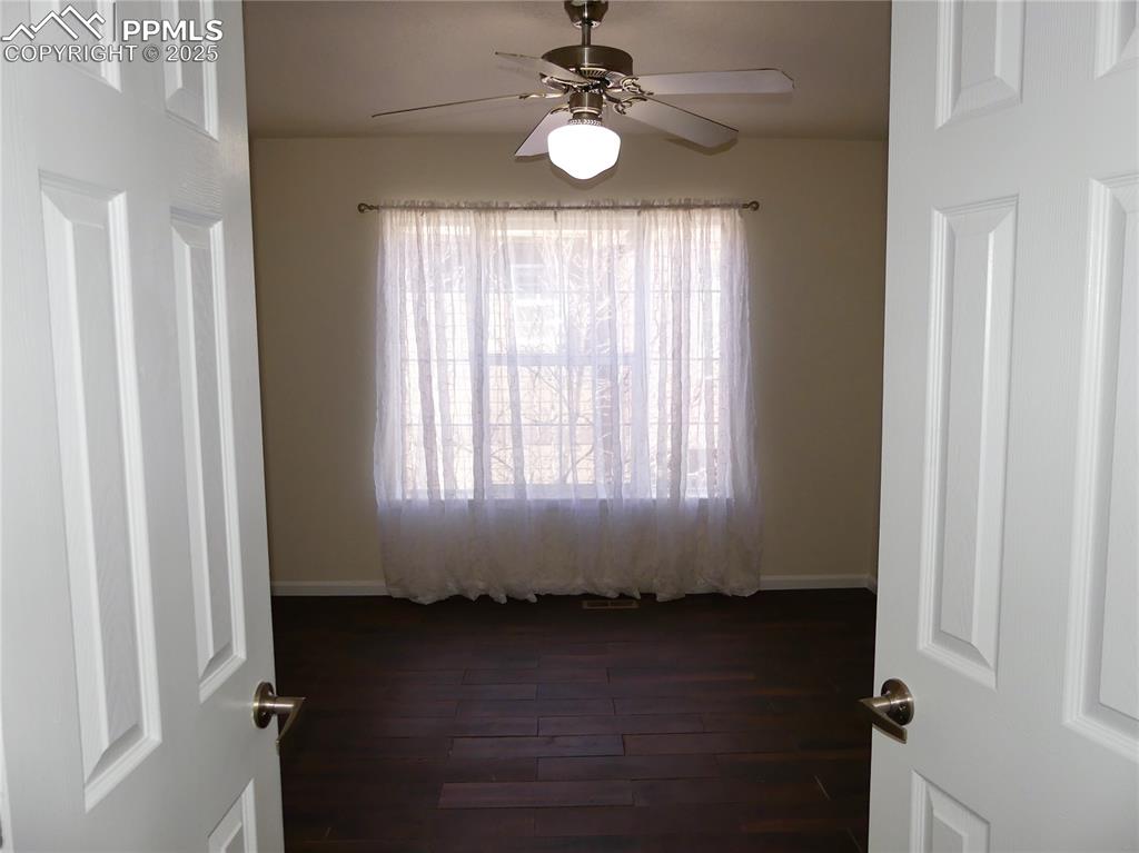 Image 13 of 33: Primary bedroom featuring dark wood-type flooring, baseboards, and ceiling