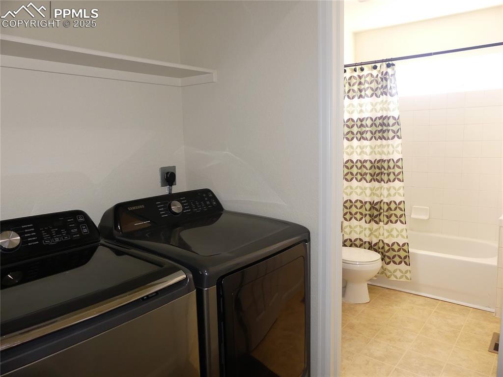 Image 25 of 33: Laundry room featuring separate washer and dryer, laundry area, and light t