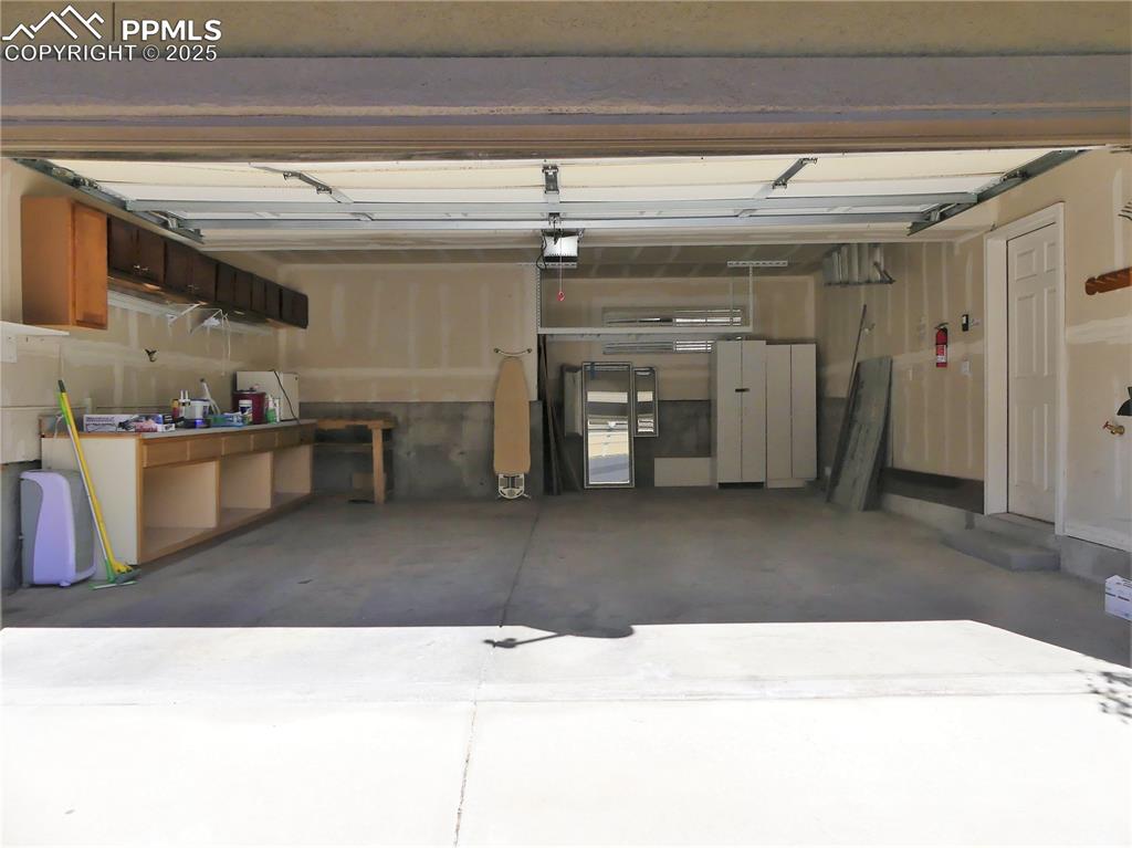 Image 28 of 33: Garage featuring a garage door opener