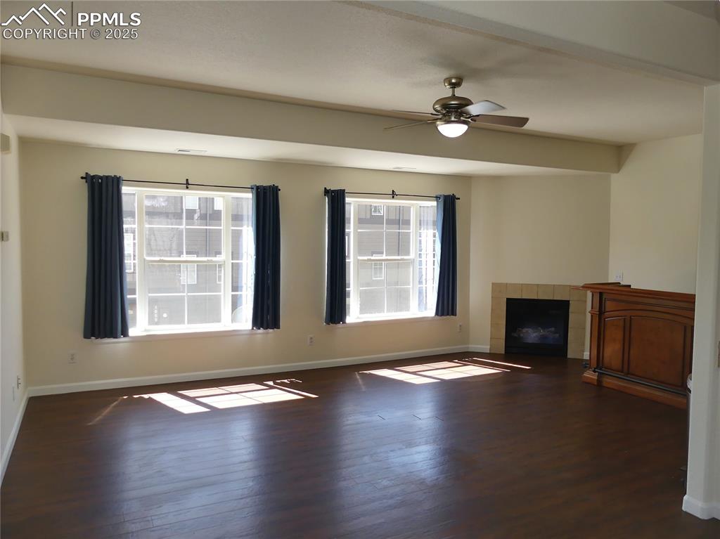 Image 4 of 33: Unfurnished living room with baseboards and wood finished floors