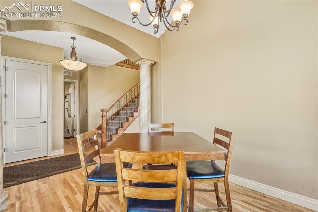 Image 10 of 49: Dining space featuring arched walkways, ornate columns, light wood-style fl