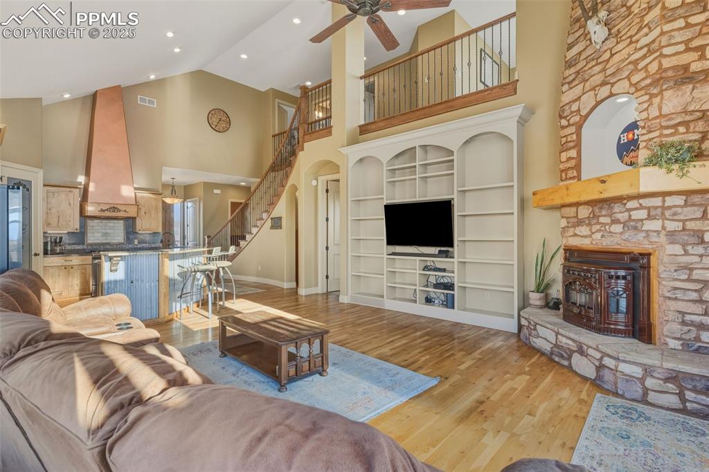 Image 13 of 49: Living area with high vaulted ceiling, light wood-style floors, built in fe