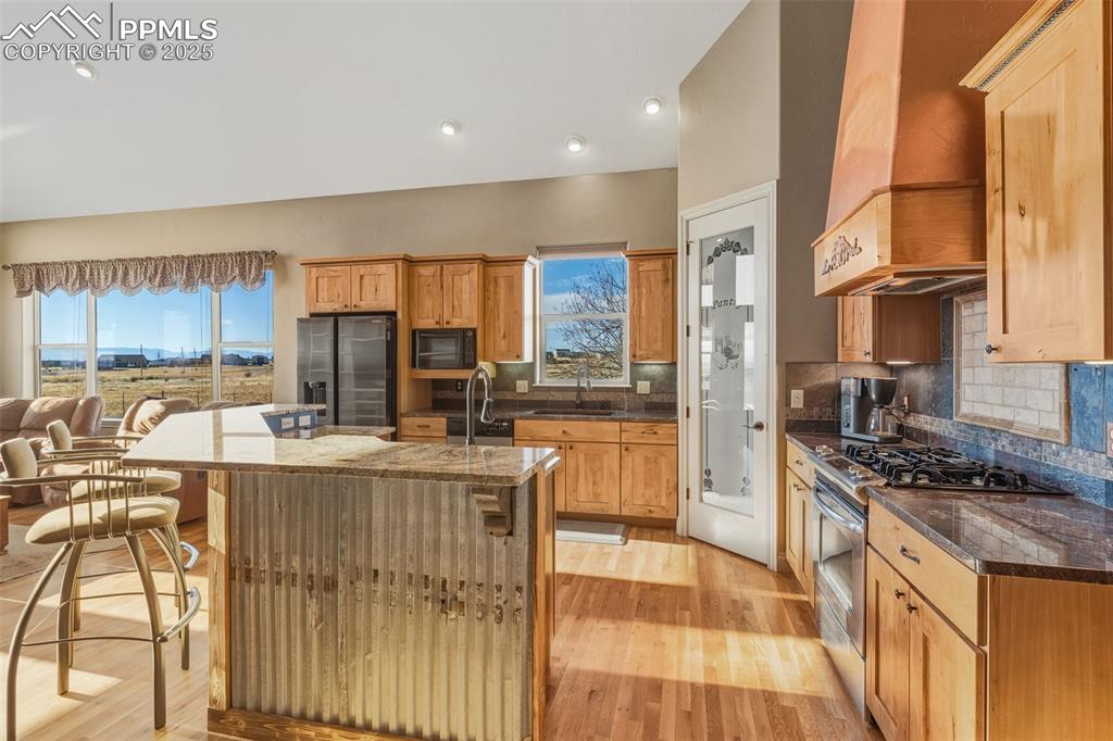 Image 15 of 49: Kitchen featuring stainless steel appliances, premium range hood, a kitchen