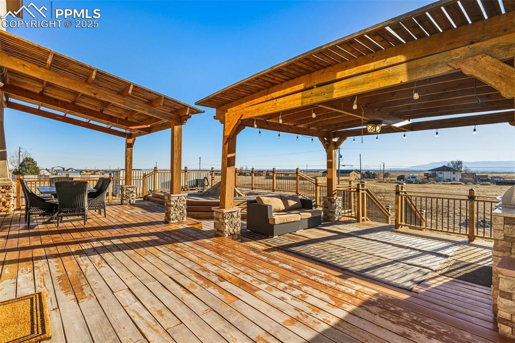 Image 37 of 49: Wooden terrace featuring outdoor dining space and outdoor lounge area
