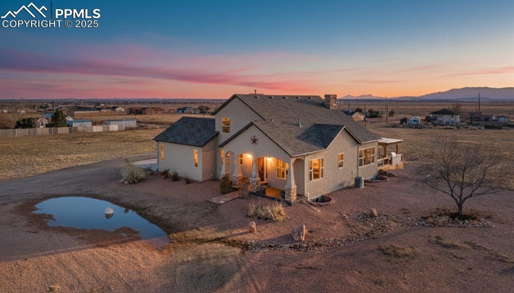 Image 4 of 49: View of front of house featuring a shingled roof, a chimney, a patio, and s