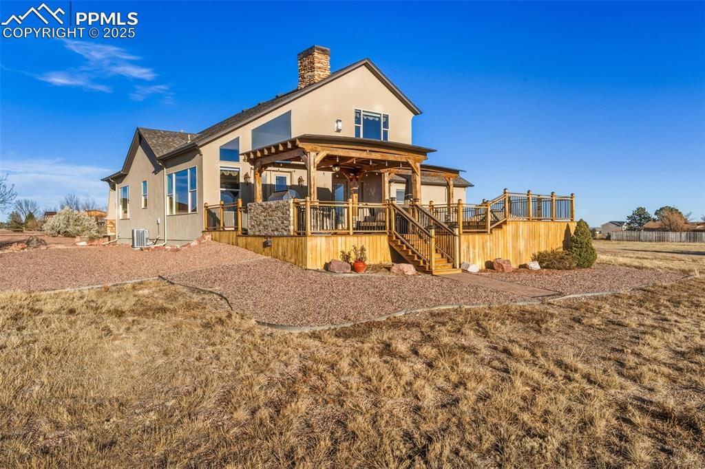 Image 40 of 49: Back of house with a deck, a chimney, and stairway