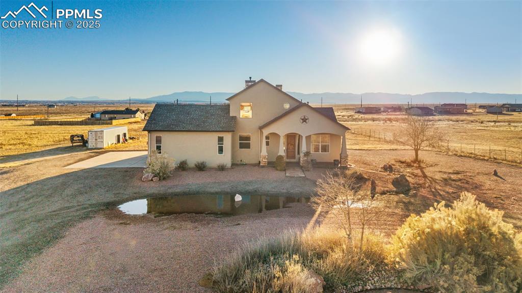 Image 42 of 49: View of front of home with stucco siding, a mountain view, a patio area, a 